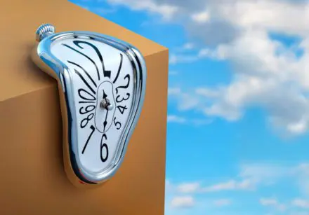 Image of a clock melting over the edge of a box.