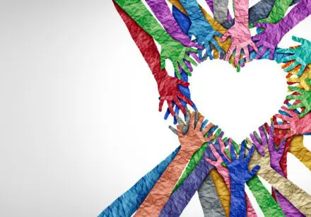 hands of different colours making an outline of a heart