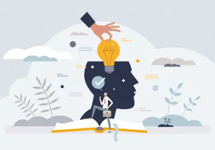 Conceptual image showing a head that's missing the top, with a lightbulb being placed into where the brain is. The head is on top of an open book and there's images of plants, clouds, and the sky around.