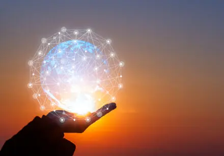 Hand outstretched holding the Earth as a sphere of light, with what seems like connected dots (indicating satellites) surrounding it.