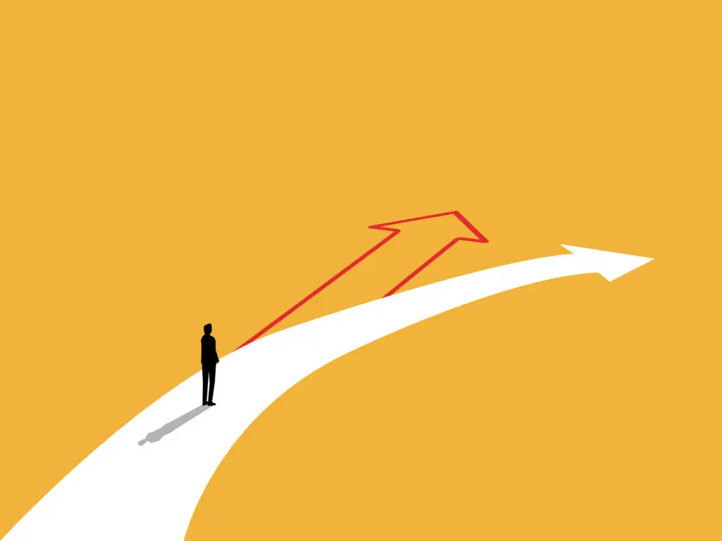 Novelty. Man standing on a large white arrow that bends to the right. The route ahead is a red arrow. The image suggests that we can choose something different. The background is mustard yellow.