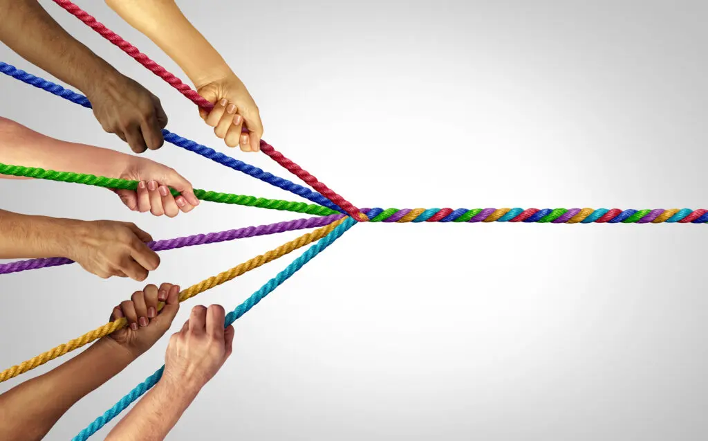 Image depicting psychological richness. Each experience colours who we becomes. Image shows different people holding a different colour of rope, and they all wind into a single multi-coloured rope