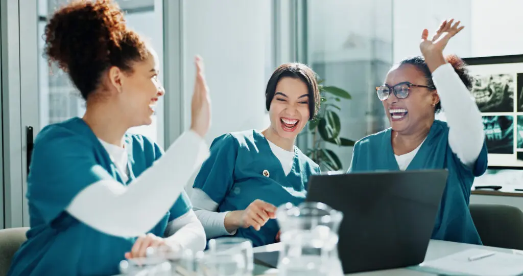 Illustration of collective effervescence. Three nurses laughing and high-fiving each other.