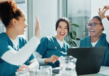 Illustration of collective effervescence. Three nurses laughing and high-fiving each other.